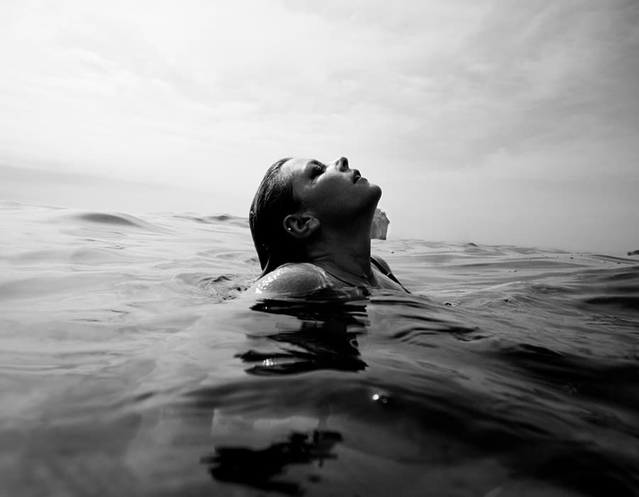 Floating in still water, face turned to the sky